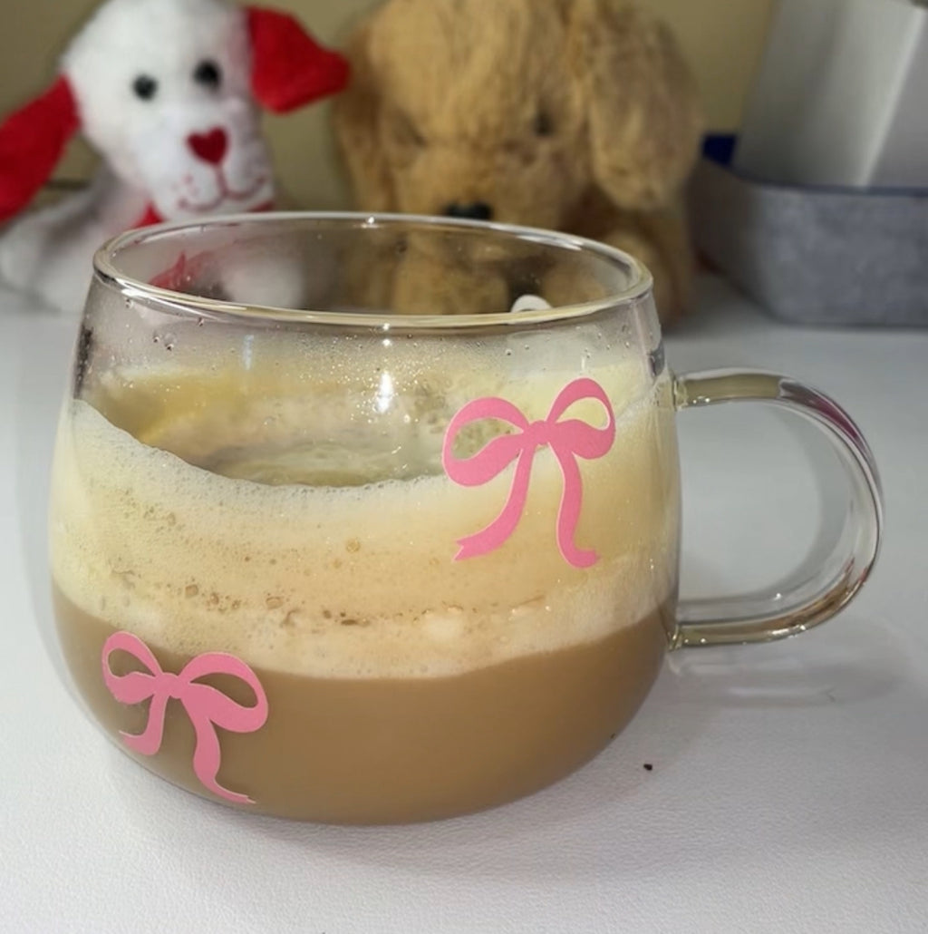 Pink Bow Glass Cup – Cute & Aesthetic Mug for Coffee, Tea & Gifting, shown filled with coffee, highlighting its charming pink bow accents and cozy vibe.